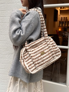 Détail d'un sac bandoulière en peluche rayé marron et blanc avec texture douce bouclée