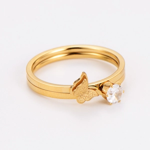 Macro shot of gold butterfly ring featuring prong-set cubic zirconia stones and dual band detail