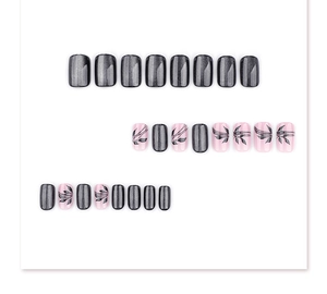Detail view of black cat-eye nails and pink floral leaf press-on nails in square shape