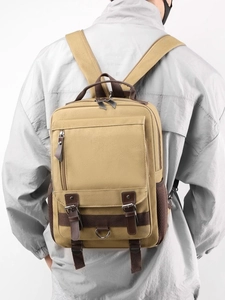 Vintage khaki canvas backpack for men with dark brown leather straps shown on model