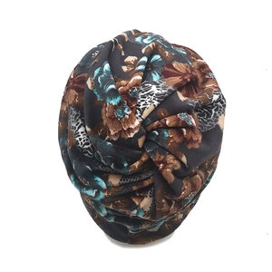Detail view of turban hat featuring floral and leopard print with central knot detail