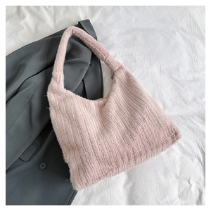 Detail showing plush texture of pink faux fur tote bag on a grey suit background