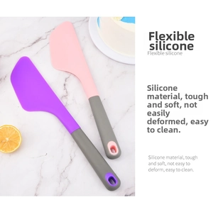 Detail view of purple and grey silicone spatulas with hanging holes on marble surface