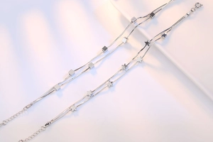 Detail of silver double-layered star and cube charm bracelet with lobster clasp