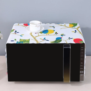 Close-up of linen microwave cover featuring colorful cartoon birds and scalloped edges