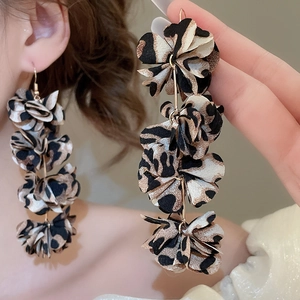 Macro shot of long leopard print fabric flower earrings with golden metal hooks