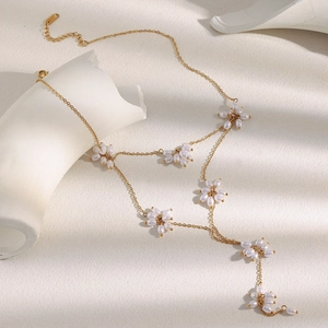 Detail of 18K gold-plated Y-necklace featuring elegant pearl flowers and golden beads