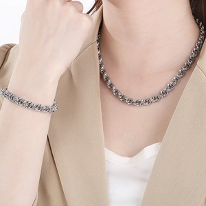 Detailed view of silver twisted rope chain necklace and bracelet set on a fashion model