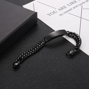 Macro view of black stainless steel Cuban link bracelet with smooth ID plate detail