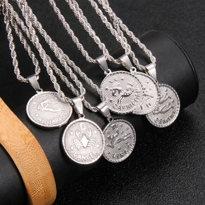 Macro view of silver zodiac coin pendants with engraved astrological names on rope chains