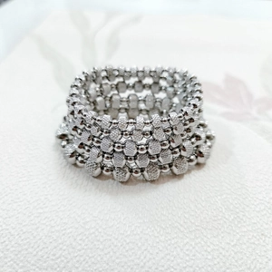 Macro shot of silver elastic beaded bracelet with smooth round and matte square textures