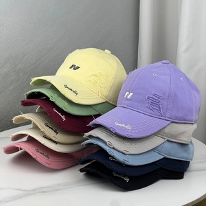 Detailed pile of distressed baseball caps featuring embroidered N logo and vintage wash