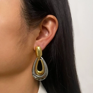 Exaggerated contrast two-tone gold and silver waterdrop earrings on female model