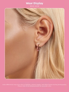 Close-up of s925 sterling silver heart hoop earrings with pink gradient on model