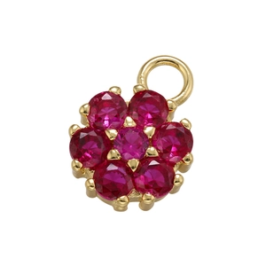 Macro shot of gold floral pendant featuring vibrant red gemstones in a six-petal design