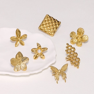 Detail view of assorted gold stainless steel flower and butterfly rings with pearls
