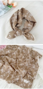Detail of coffee linen scarf with delicate white floral prints and lace trim edge