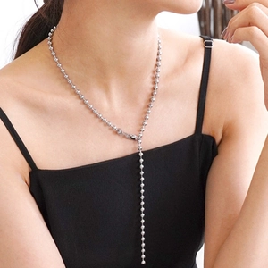 Detail view of silver bead chain necklace with lobster clasp shown on a female model