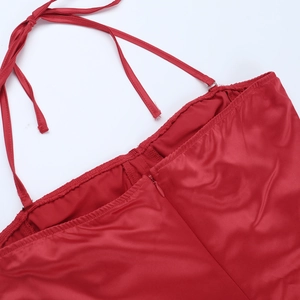 Detail of red satin backless dress showing halter ties and smooth fabric texture