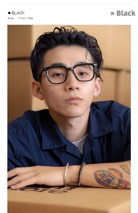 Close-up of black oversized square glasses frame worn by a model in a retro studio setting