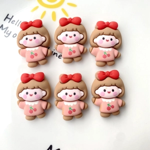 Flat lay of cute resin girl charms with pink cherry details for DIY phone case crafts