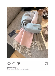Detail shot of 100% wool scarf with grey blue pink patchwork and fringe on a sofa
