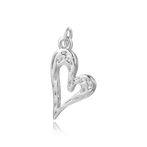 Macro shot of silver textured hollow heart pendant with hammered finish and jump rings