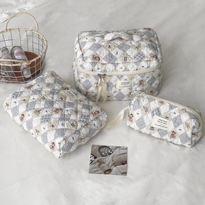 Three-piece quilted makeup bag set with blue checkered teddy bear and floral patterns