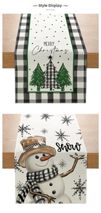 Detail of Christmas table runners with snowman and tree prints on linen-like fabric