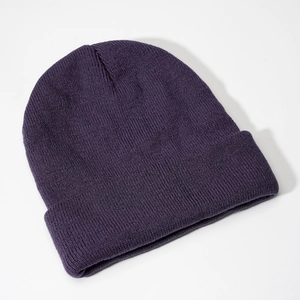 Close-up of deep purple knit beanie showing detailed vertical ribbed texture and folded cuff