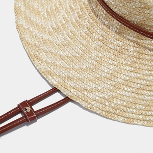 Straw sun hat with wide brim, brown leather strap, and intricate weave detail