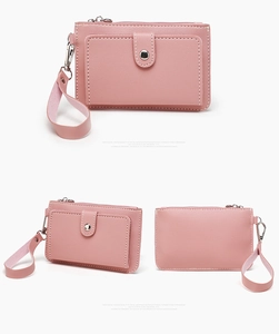 Detailed view of pink PU leather coin purse with stitching, snap pocket and wrist strap