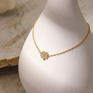 Nahaufnahme eines goldenen Ahornblatt-Anhängers mit weißen Zirkonia an feiner Kette