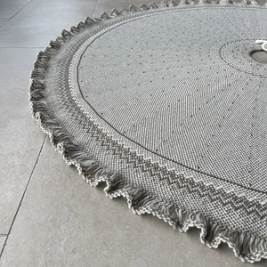 Close-up of knitted Christmas tree skirt with geometric texture and fringe edge
