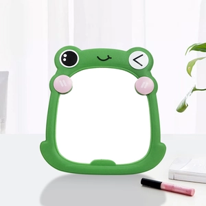 Detail of cute green frog desktop makeup mirror with pink blush and silicone frame