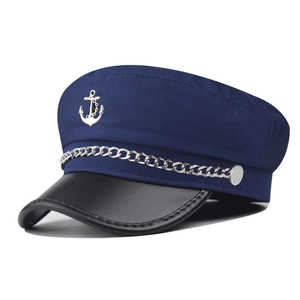 Detail of silver anchor emblem and metal chain on navy blue sailor military hat