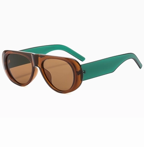 Detail view of oval sunglasses featuring brown frames and green temples with tan lenses