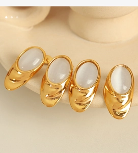 Close-up of 18k gold plated titanium earrings featuring white opal stones and vintage textures