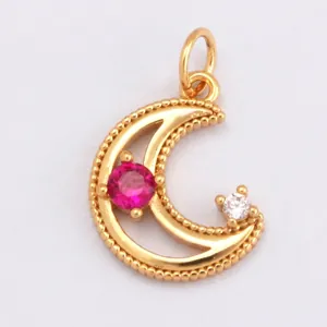 Macro view of gold moon pendant with pink gemstone and granular texture detail