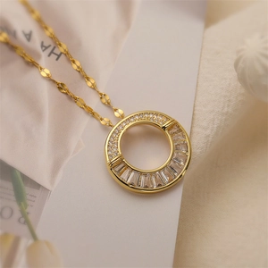 Macro detail of gold plated teardrop pendant featuring micro-pave and baguette cut zircons