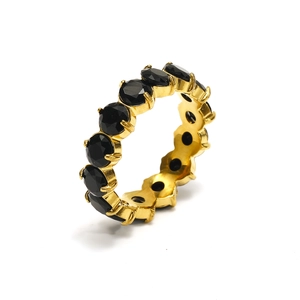 Detailed macro view of 18K gold eternity ring with round black zircon stones in prong setting