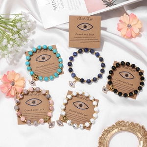 Five assorted natural stone bead bracelets with evil eye charms on elegant white silk
