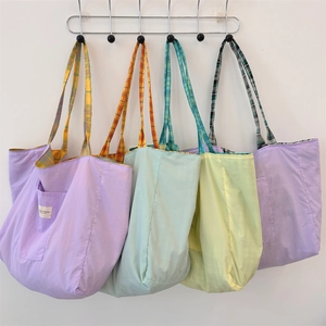 Vue détaillée des sacs cabas en toile lilas et vert menthe avec bandoulières à carreaux