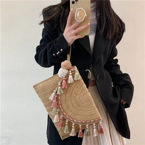 Bohemian straw envelope bag with colorful tassels and pompoms for beach vacation outfits