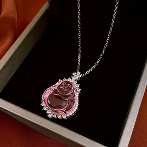 Pink gemstone Buddha pendant necklace with white zircon halo on velvet jewelry box