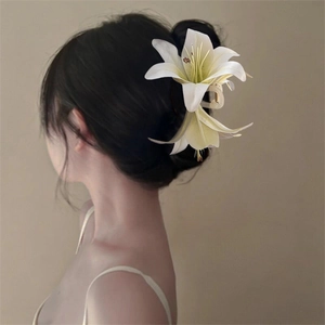 Side view of white 3D lily flower hair claw clip on model's elegant updo hairstyle