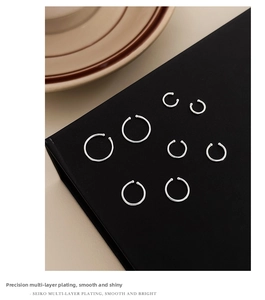 Macro detail of eight different sized silver-plated hoops on black matte display board