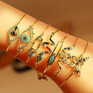 Detailed close-up of golden eye and butterfly bracelets with colorful cubic zirconia