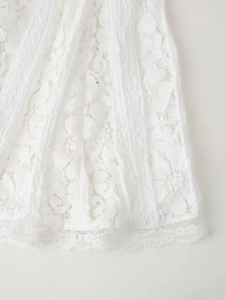 Détails de broderie en dentelle blanche sur l'ourlet d'une robe longue ajustée