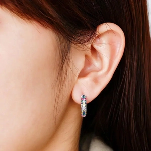 Macro shot of silver ear cuff with vibrant multicolored zircon stones for daily wear